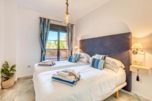 a bedroom with two beds and a large window at Deluxe relax apartment with pool in Estepona +39 photos