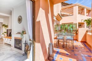 a living room with a fireplace and a patio at Deluxe relax apartment with pool in Estepona