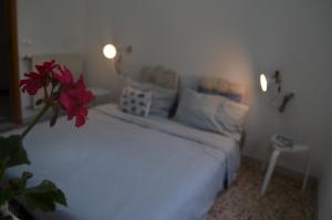 Nulvi的住宿－Porto Cielo Nord Sardegna，一间卧室配有一张带红花的白色床