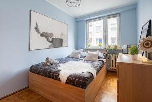 ein Schlafzimmer mit einem Bett in einem Zimmer mit blauen Wänden in der Unterkunft NiceOne Apartment Number 1 - W samym Centrum! in Breslau