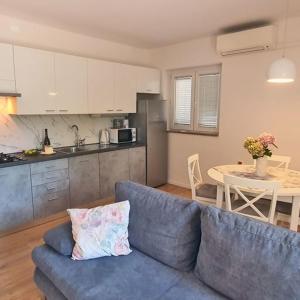 een woonkamer met een blauwe bank en een keuken bij AURELIO in Rijeka