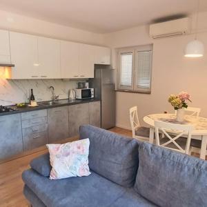 a living room with a blue couch and a kitchen at AURELIO in Rijeka