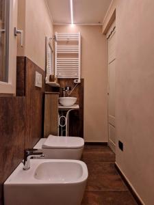 a bathroom with a white sink and a toilet at Mister Barolo Apartments Langhe in Novello +37 photos
