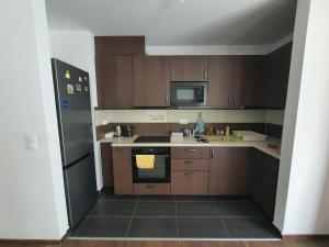 a kitchen with wooden cabinets and a black refrigerator at Park West Apartment - Free Parking in Budapest