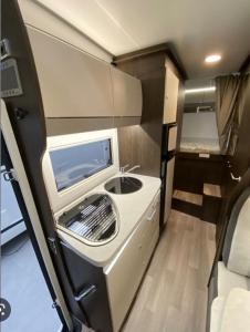 uma cozinha com uma máquina de lavar roupa num trailer em Portugals Infinity - AutoCaravana Luxo em Faro