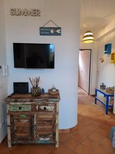 a living room with a tv on a wall at La Casa sulla Spiaggia in Marzamemi