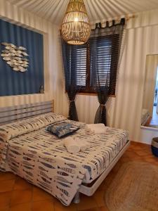 een slaapkamer met een bed en een kroonluchter bij La Casa sulla Spiaggia in Marzamemi