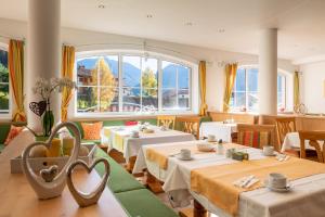 ein Restaurant mit Tischen und Stühlen und einem großen Fenster in der Unterkunft Hotel Thaneller Stadl Bräu in Berwang