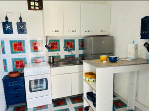 una pequeña cocina con armarios blancos y fregadero en Perla Salina, en Leni