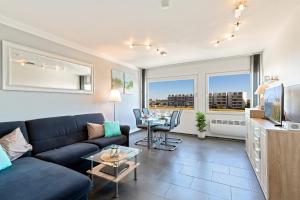 a living room with a blue couch and a tv at Burgtiefe Südstrand "Seestern" in Fehmarn