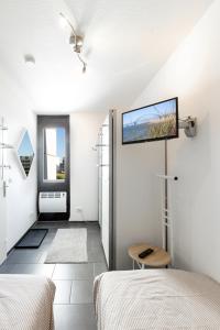 a bedroom with two beds and a tv on the wall at Burgtiefe Südstrand "Seestern" in Fehmarn