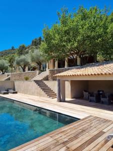 a house with a swimming pool and a wooden deck at La maison des collines in Allemagne-en-Provence
