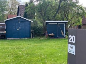 a blue shed in a yard with a sign next to it at Etage1 in Hameln