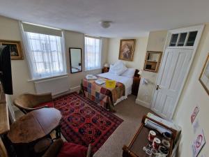 Habitación de hotel con cama y sala de estar. en Black Horse Canterbury en Canterbury