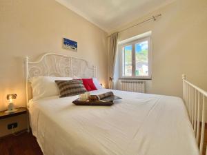Una cama blanca con una bandeja de comida. en CasaViva - Lovely SeaView Trilo in Genova Nervi en Génova