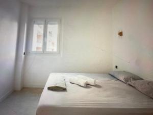 een witte slaapkamer met een bed en een raam bij Appartement Avec Terrasse Centre-ville Croisette in Cannes