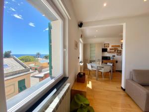 ein Wohnzimmer mit einem großen Fenster und einem Esszimmer in der Unterkunft CasaViva - Lovely SeaView Trilo in Genova Nervi in Genua