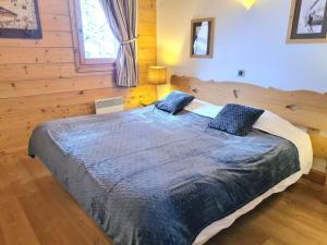 um quarto com uma cama grande num chalé de madeira em Appartement Le D12 Samoëns em Samoëns
