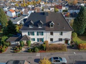 une grande maison blanche avec un toit noir dans l'établissement Attendorner Burgblick, à Attendorn