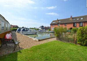 a house with a yard with boats in the water at 20 Trail Quay Cottages in Hoveton