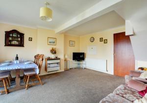 a living room with a table and a couch at 20 Trail Quay Cottages in Hoveton