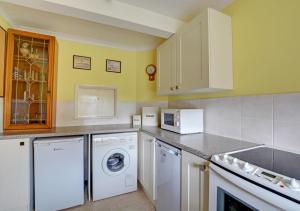a kitchen with a washing machine and a washer and dryer at 20 Trail Quay Cottages in Hoveton