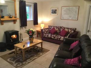 a living room with a couch and a fireplace at Abby's Cottage Roundstoneselfcatering in Roundstone