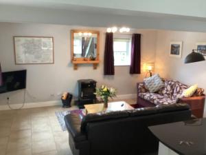 a living room with a couch and a table at Roundstone Retreats Abbys cottage in Roundstone +22 photos