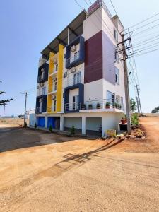 um edifício ao lado de uma estrada de terra batida em MITRA HOTELS em Mysore