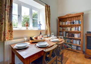 a dining room with a wooden table and a book shelf at The Old Chapel in Hindolveston