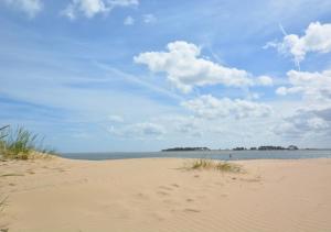 a beach with footprints in the sand and the ocean at Flat 8 The Granary in Wells next the Sea