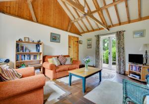 a living room with a couch and a table at Wayfarers Cottage in Mattishall