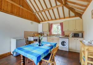 a kitchen with a table with a blue table cloth at Wayfarers Cottage in Mattishall