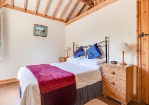 a bedroom with a large bed and a wooden ceiling at Wayfarers Cottage in Mattishall