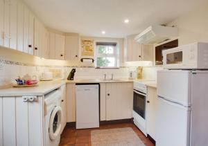 a kitchen with white appliances and white cabinets at The Old Chapel in Banningham