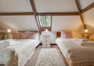 a attic bedroom with two beds and a window at The Old Chapel in Banningham