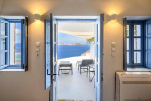 a door leading to a balcony with a view of the ocean at Karpimo Scenery - Caldera Sunset View - Private Hot Tub - Firostefani in Firostefani