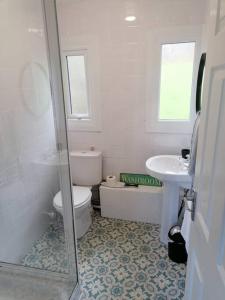 biała łazienka z toaletą i umywalką w obiekcie Hillside Chalet w mieście Kilkhampton