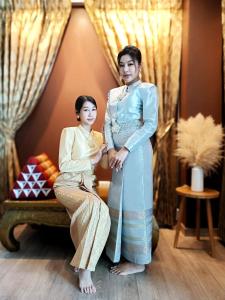 a woman in a kimono standing next to another woman at YAKTHAI POSHTEL in Bangkok