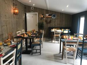une salle à manger avec des murs en bois, des tables et des chaises dans l'établissement Ons Hofke, à Lubbeek