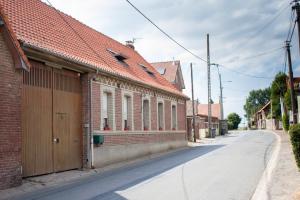 a brick building with a garage on the side of a street at Chez mumu in Frévillers +6 photos