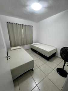a room with two beds and a chair in it at AP - Os Três Pandeiros in Campina Grande