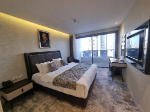 a bedroom with a large bed and a large window at Reggenza Hotel Downtown Ramallah in Ramallah