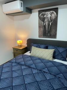 1 dormitorio con 1 cama con una foto de elefante en la pared en Damade apartments, en Jajce