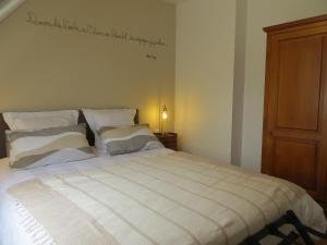 een slaapkamer met een groot wit bed met kussens bij Le temps d'un séjour en Bretagne Chambres d'hôtes in Nivillac