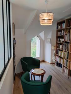 een woonkamer met 2 groene stoelen en een tafel bij Le temps d'un séjour en Bretagne Chambres d'hôtes in Nivillac