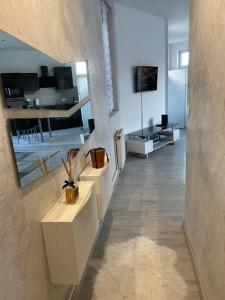 un soggiorno con mobili bianchi e una camera con specchio di Appartement Belfort proche gare a Belfort