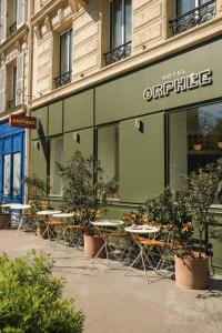 ein Geschäft mit Tischen und Stühlen vor einem Gebäude in der Unterkunft Hotel Orphée - Orso Hotels in Paris