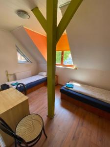 Pokój z 2 łóżkami i zielonym słupem w obiekcie Chata Mazurska Marek Pyśk w mieście Mrągowo