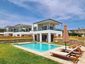 a villa with a swimming pool and a house at Mythic Seaview Villas in Kiotari